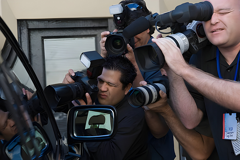 A candid shot of paparazzi photographers capturing a celebrity moment, highlighting the dynamic and often unscripted nature of paparazzi photography.